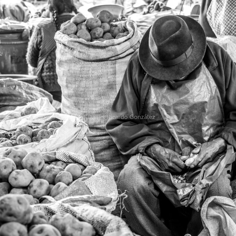 Eingeschlafener Kartoffelschäler auf Markt in Peru. Falling asleep potato peeler at market in Peru.